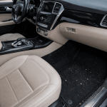 Professional technician performing deep car interior detailing inside a modern vehicle.
